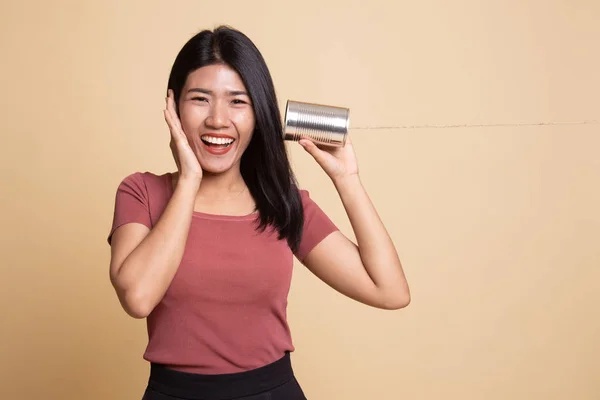 Naslouchání šťastné mladé Asijské žena s telefonem tin can. — Stock fotografie