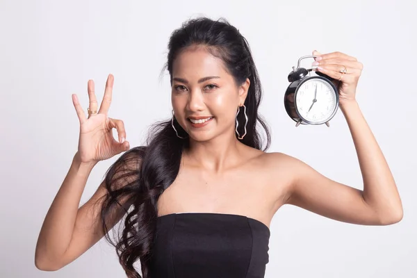 Jonge Aziatische vrouw show Ok met een klok. — Stockfoto