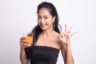 Genç Asyalı kadın içki portakal suyu göster Ok işareti.