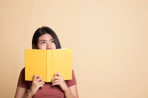 Junge asiatische Frau mit einem Buchdeckel ihr Gesicht. — Stockfoto