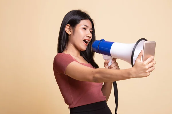 Boze jonge Aziatische vrouw schreeuwen met megafoon naar mobiele telefoon. — Stockfoto