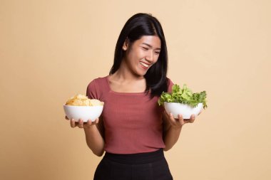 Patates kızartması ve salata ile genç Asyalı kadın.