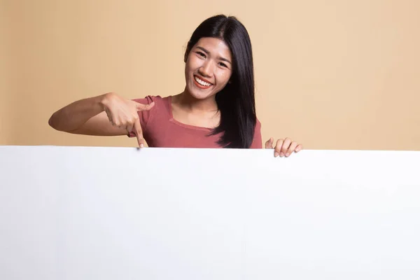 Jovem mulher asiática apontar para um sinal em branco . — Fotografia de Stock