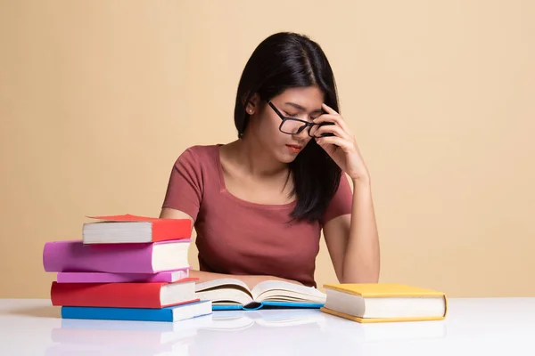 Esausto asiatico donna ottenuto mal di testa leggere un libro con libri su scheda — Foto Stock