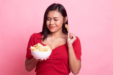 Genç Asyalı kadın yemek patates cipsi.