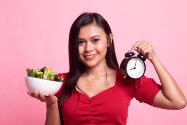 Saat ve salata ile genç Asyalı kadın.