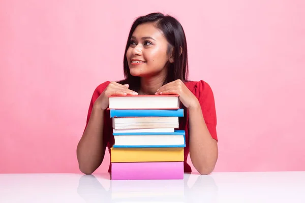 Feliz joven asiática mujer leer un libro con libros en la mesa . — Foto de Stock