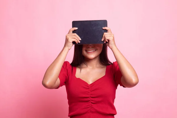 Young Asian woman with a computer tablet over her face. — Stock Photo, Image