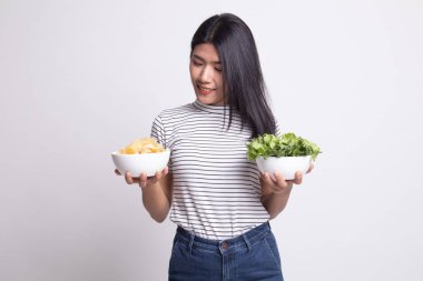 Patates kızartması ve salata ile genç Asyalı kadın.