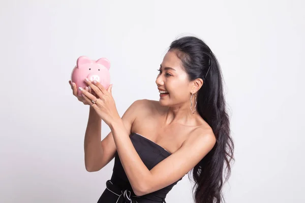 Jovem mulher asiática com um banco de moedas de porco . — Fotografia de Stock