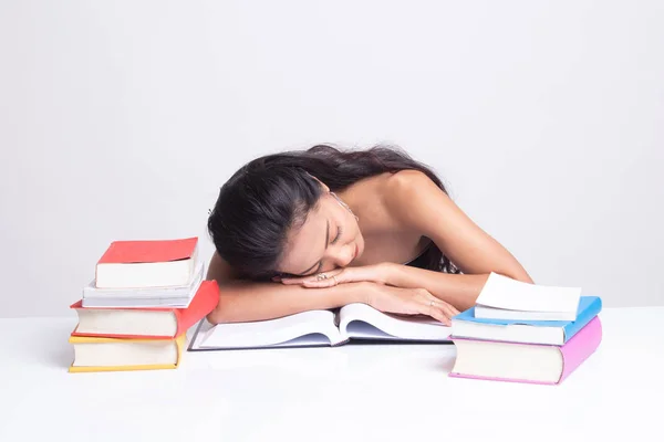 Uitgeput jonge Aziatische vrouw slapen met boeken op tafel. — Stockfoto