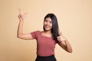Genç Asyalı kadın noktası ve başparmak yukarıya.