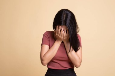 Üzgün genç Asyalı kadın avuç içi ağlar.