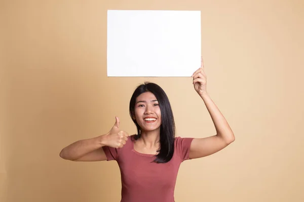 年轻的亚裔女子拇指拿着白色的空白符号. — 图库照片