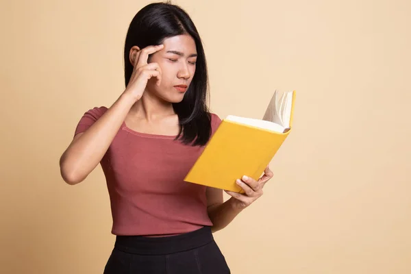 Junge asiatische Frau bekam Kopfschmerzen ein Buch lesen. — Stockfoto