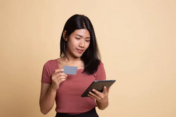 Jonge Aziatische vrouw is online winkelen met creditcard en tablet — Stockfoto