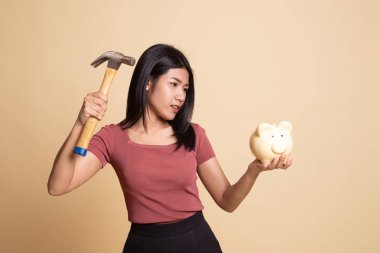 Asyalı kadın domuz para banka ve çekiç ile.