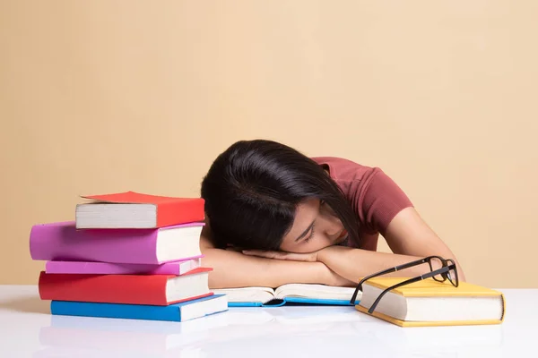 Esausto giovane donna asiatica dormire con libri sul tavolo . — Foto Stock