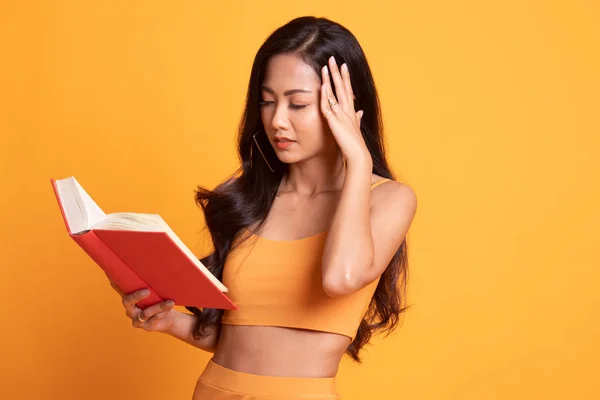 Jovem mulher asiática tem dor de cabeça ler um livro . — Fotografia de Stock