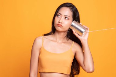 Teneke kutu telefon ile genç Asyalı kadın.