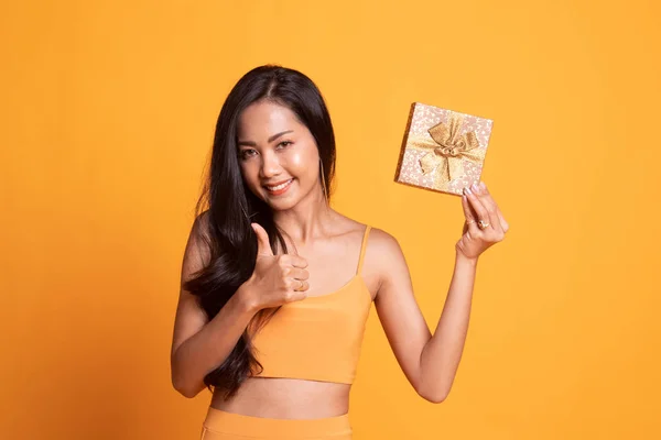 Young Asian woman thumbs up with a gift box.