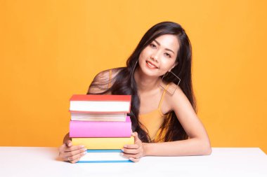 Mutlu genç Asyalı kadın kitapları tablo ile bir kitap okumak.