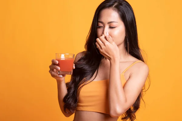 Young Asian woman hate tomato juice.
