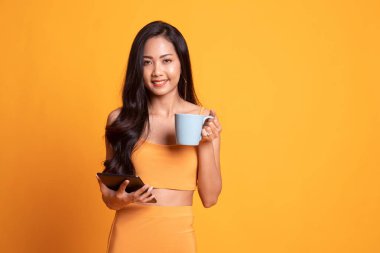 Bir bilgisayar tablet ve kahve ile genç Asyalı kadın.