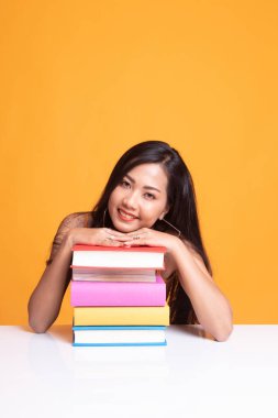 Mutlu genç Asyalı kadın kitapları tablo ile bir kitap okumak.