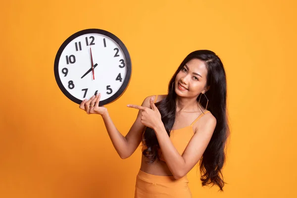 Mladá asijská žena bod do hodiny. — Stock fotografie