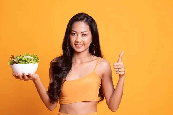 Healthy Asian woman thumbs up with salad.