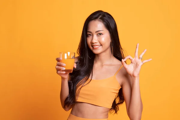 Νεαρή γυναίκα ασιατικό ποτό χυμό πορτοκάλι παρουσιάζουν εντάξει σύμπτωμα. — Φωτογραφία Αρχείου