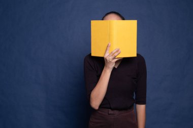 Bir kitapla genç Asyalı kadın kapak yüzü.