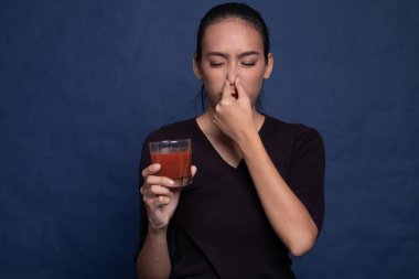 Genç Asyalı kadın nefret domates suyu.