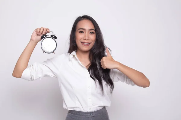 Young Asian woman show thumbs up with a clock. — Stock Photo, Image