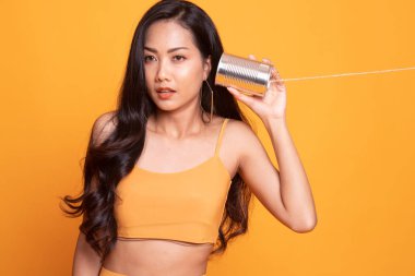 Teneke kutu telefon ile sürpriz genç Asyalı kadın.