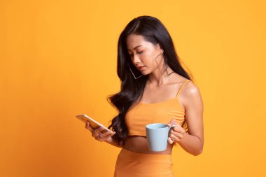 Genç Asyalı kadın ile cep telefonu ve kahve fincanı.