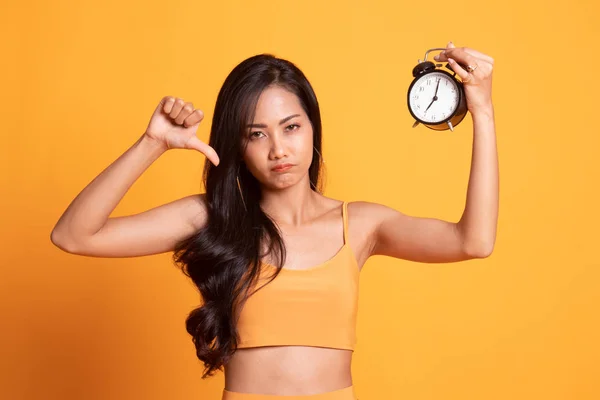 Jeune femme asiatique pouces vers le bas avec une horloge . — Photo