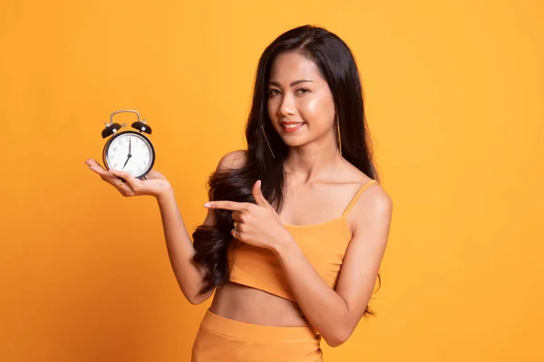 年轻的亚裔女子点到时钟. — 图库照片