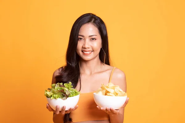 Giovane donna asiatica con patatine e insalata . — Foto Stock