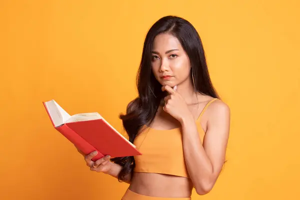 Jovem mulher asiática com um livro está pensando . — Fotografia de Stock