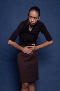 Genç Asyalı kadın mide ağrısı var.