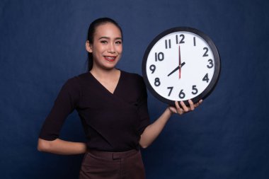 Saati olan genç Asyalı kadın..