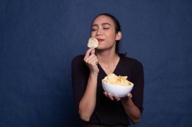 Genç Asyalı kadın yemek patates cipsi.