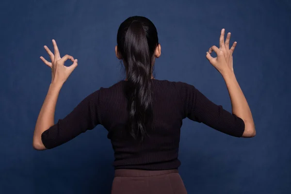 Indietro vista di asiatico donna spettacolo doppio ok mano segno . — Foto Stock