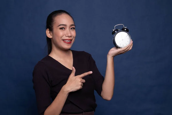 Young Asian woman point to a clock. — Stock Photo, Image