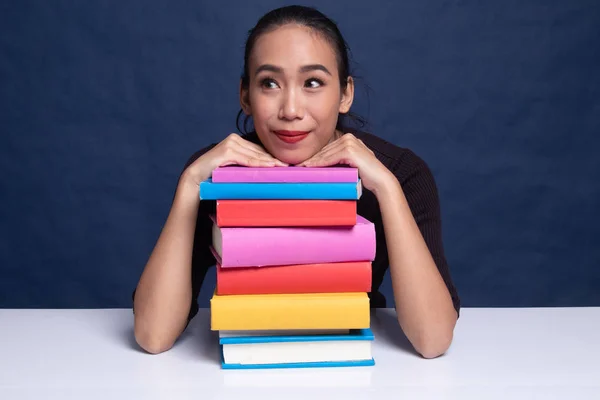 Szczęśliwa młoda kobieta azjatyckich czytać książki z książek na stole. — Zdjęcie stockowe
