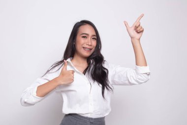 Genç Asyalı kadın noktası ve başparmak yukarıya.