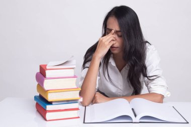 Yorgun Asyalı kadın baş ağrısı okuma sekmesinde kitaplarla bir kitap aldım.