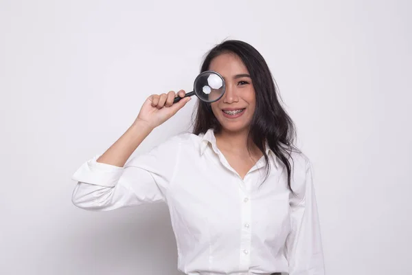 Young Asian woman with a magnifying glass. — Stock Photo, Image